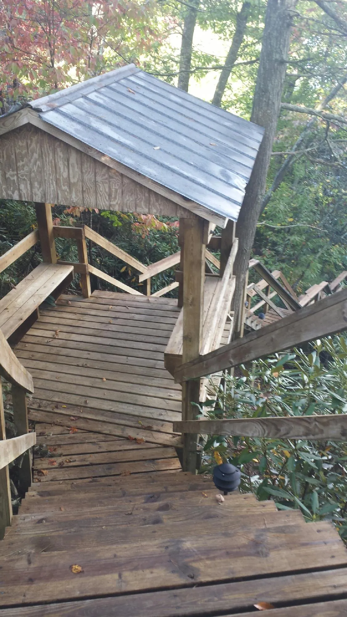 Metal roofed shelter over wooden steps on a wooded walkway — Skylight Repair & Installation work by our crew in Van Wert
