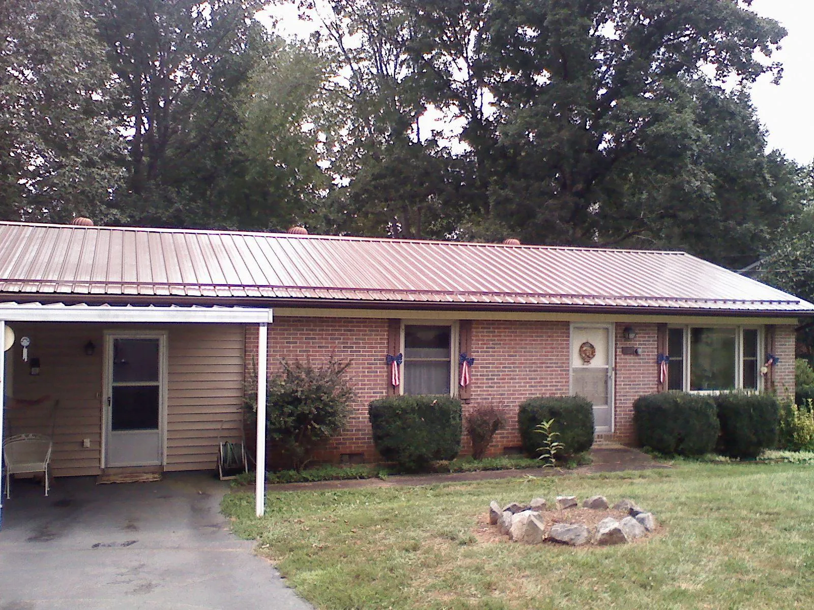 Bronze metal roof and carport on a brick ranch home — Roof Repair work by our crew in Van Wert